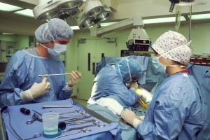 Operating room with two surgeons and a nurse. Courtesy National Cancer Institute.
