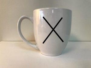 Coffee mug with a black X.