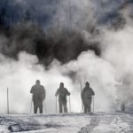 Three people in snow on cross country skis