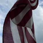 American flag with clouds in background