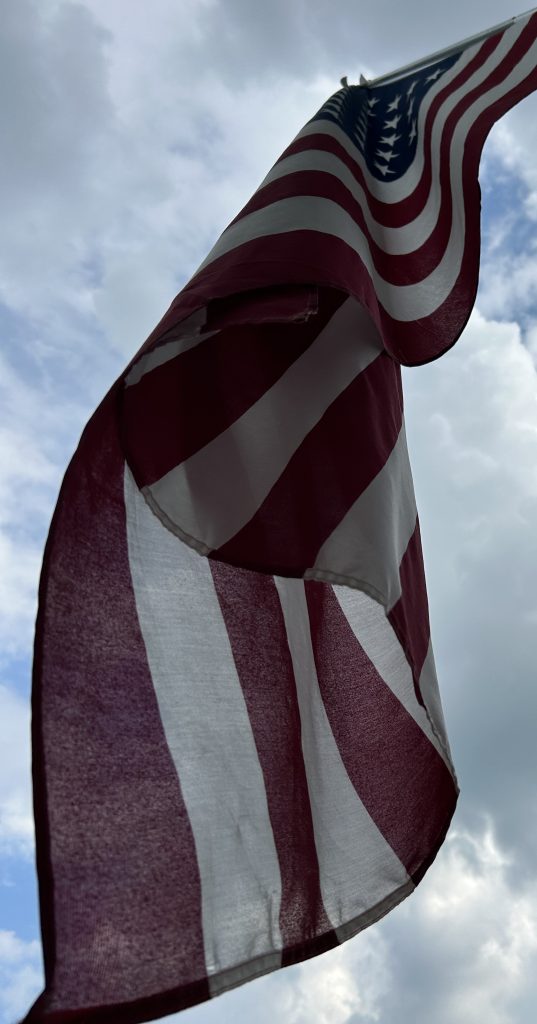 American flag with clouds in background