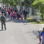 Migrants approach CBP officer at the border. Photo by Kris Grogan.