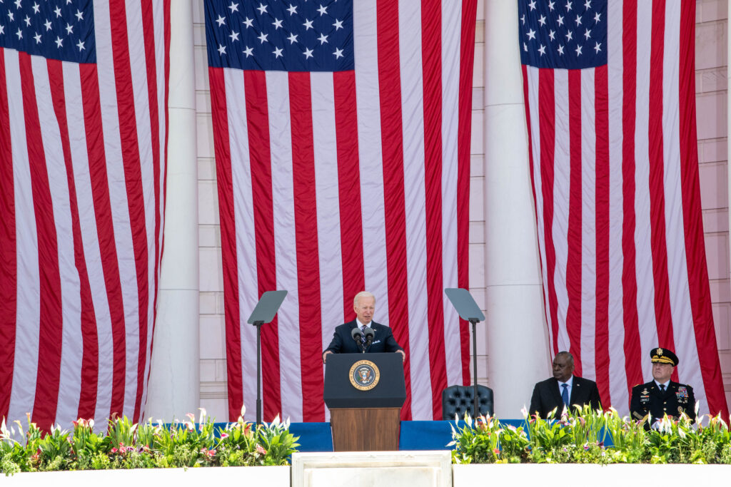 President Biden standing before three American flags. U.S.  Dept of Defense photo. 