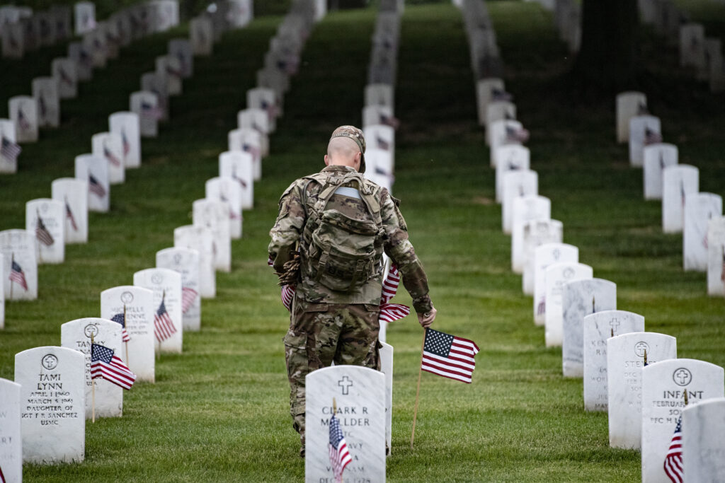 Soldier laying flags at Arlington Cemetery. (U.S. Army photo by Elizabeth Fraser / Arlington National Cemetery/released)