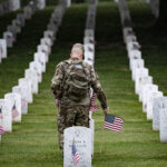 Soldier laying flags at Arlington Cemetery. (U.S. Army photo by Elizabeth Fraser / Arlington National Cemetery/released)